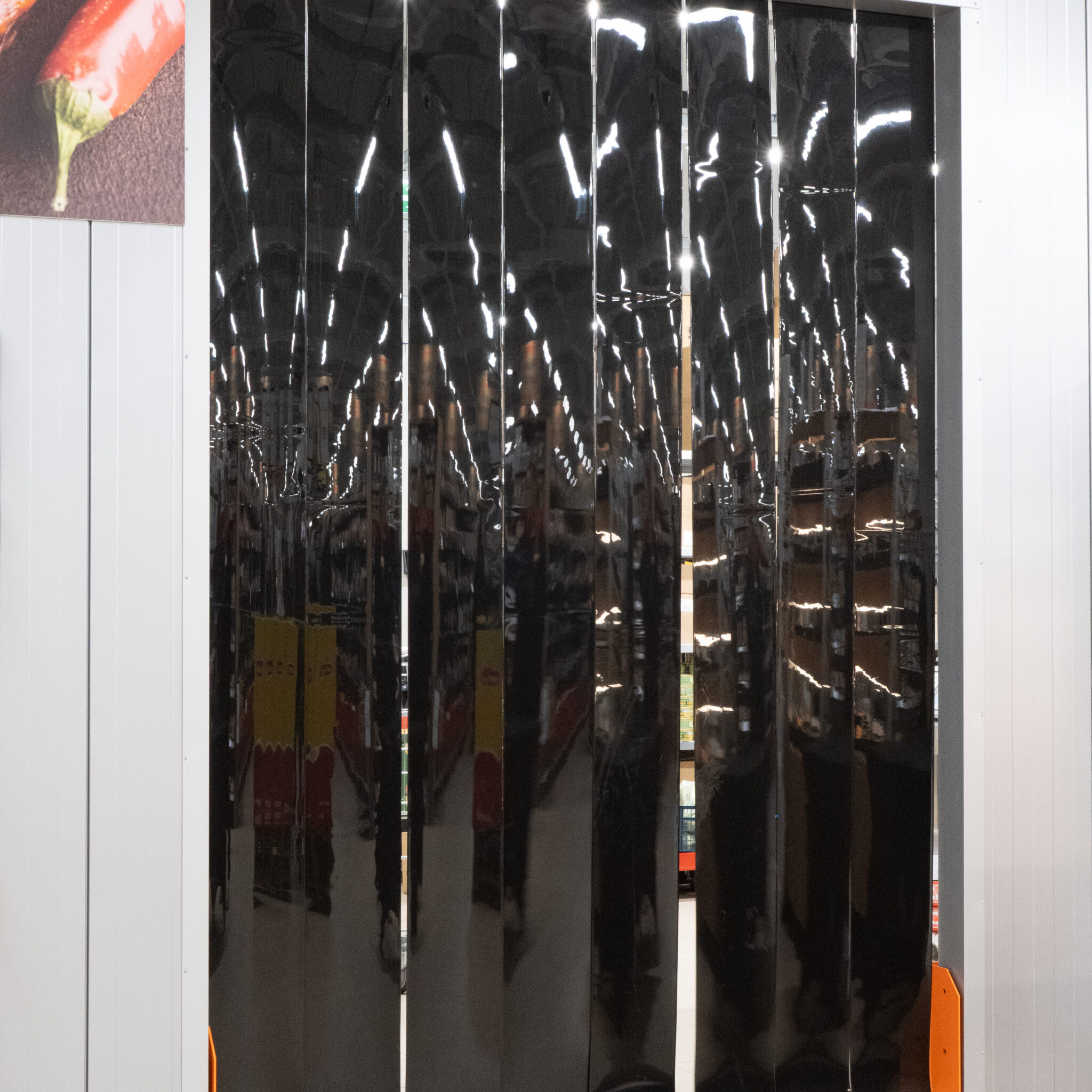 Läikiv must uks poeinterjööri peegeldusega.