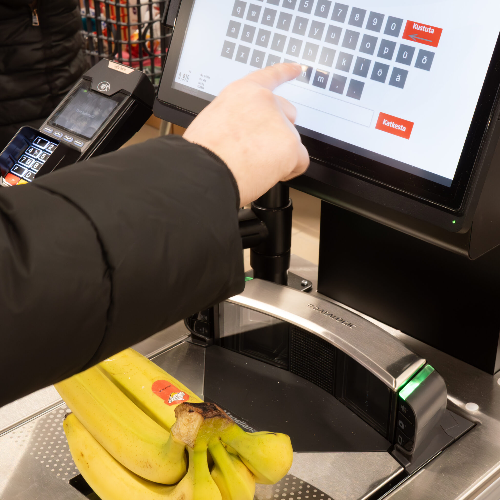 Inimene kaalub kassas banaane.