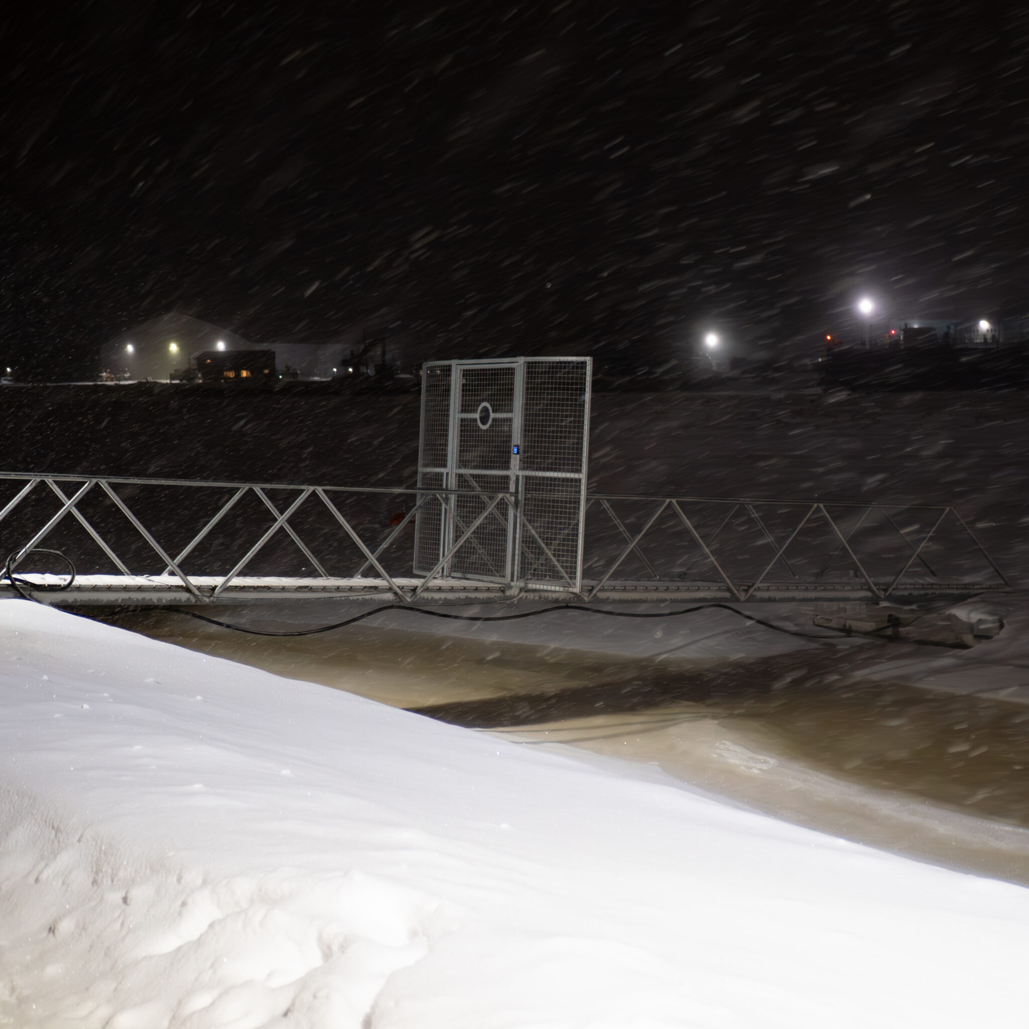 Sild üle jõe lumisel ööl.